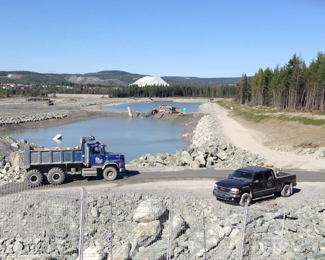 Camion-benne et enrochement sur un chantier de génie civil à Thetford Mines, haldes minières en arrière-plan